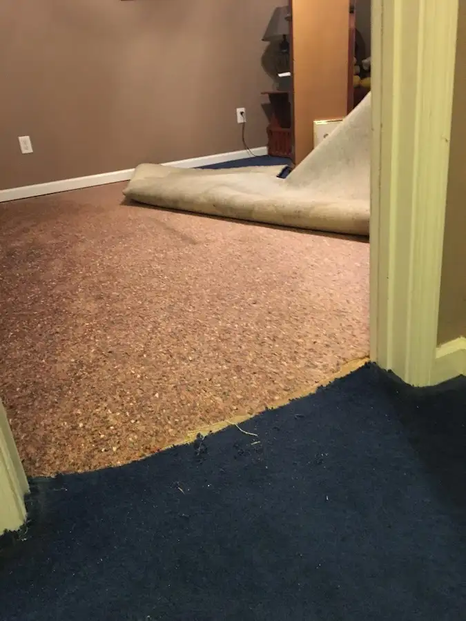 Carpet pad removal revealing water damage during Water Mitigation Services in Durham